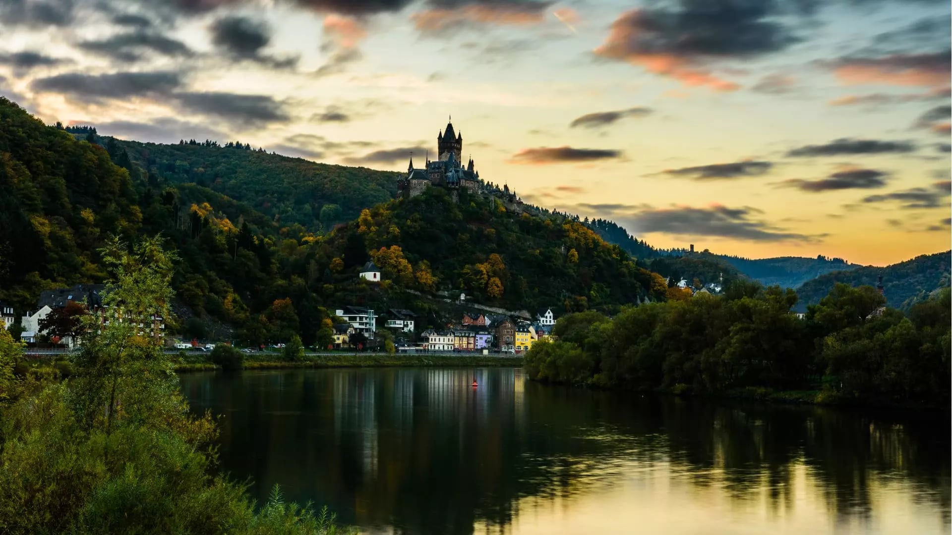 Blick auf die Mosel bei Sonnenuntergang mit der Burg Eltz im Hintergrund